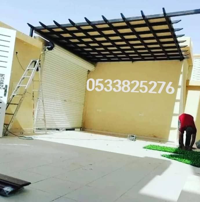 برجولة بعوارض سوداء متقاطعة فوق مدخل كراج أثناء تجهيز الموقع